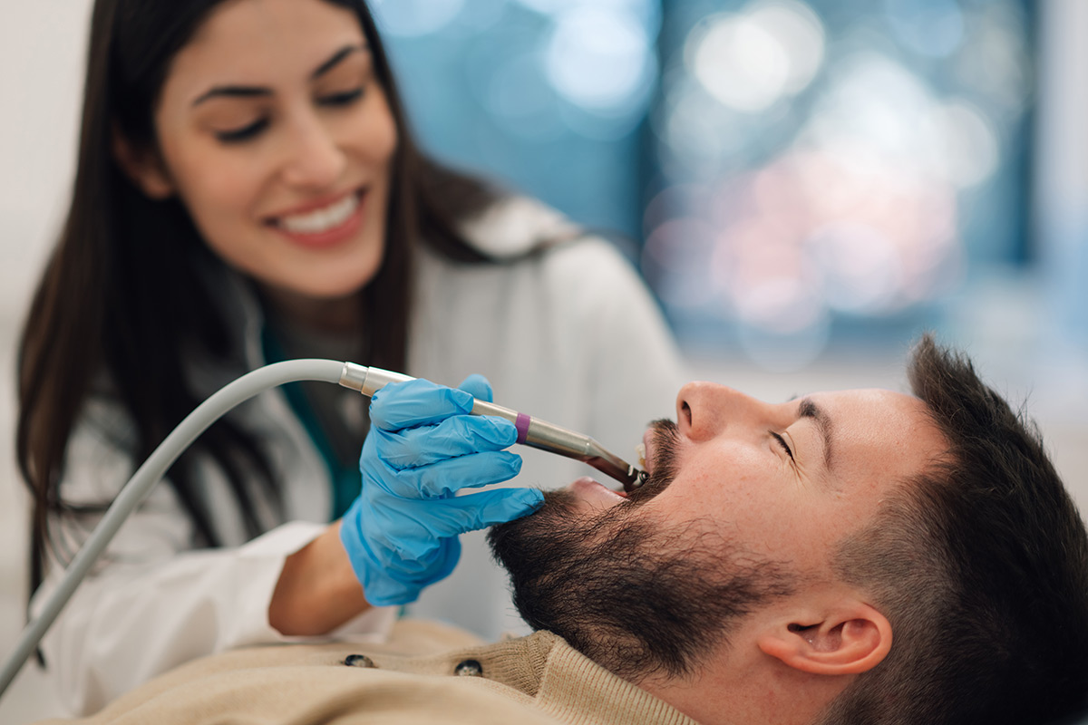 Patient admiring her restored smile in a hand mirror