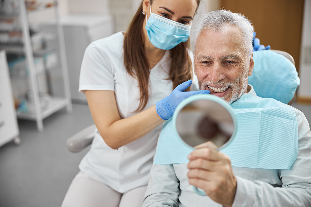 Dental professional showing a patient his restored smile